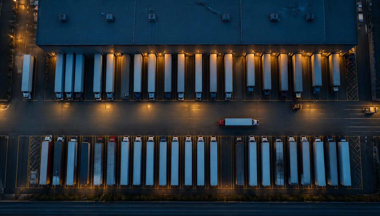 Aerial view of trailers staged at dock doors in a freight yard at dusk